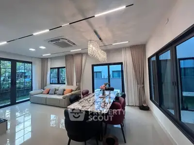 Luxurious modern living room with elegant chandelier and garden view