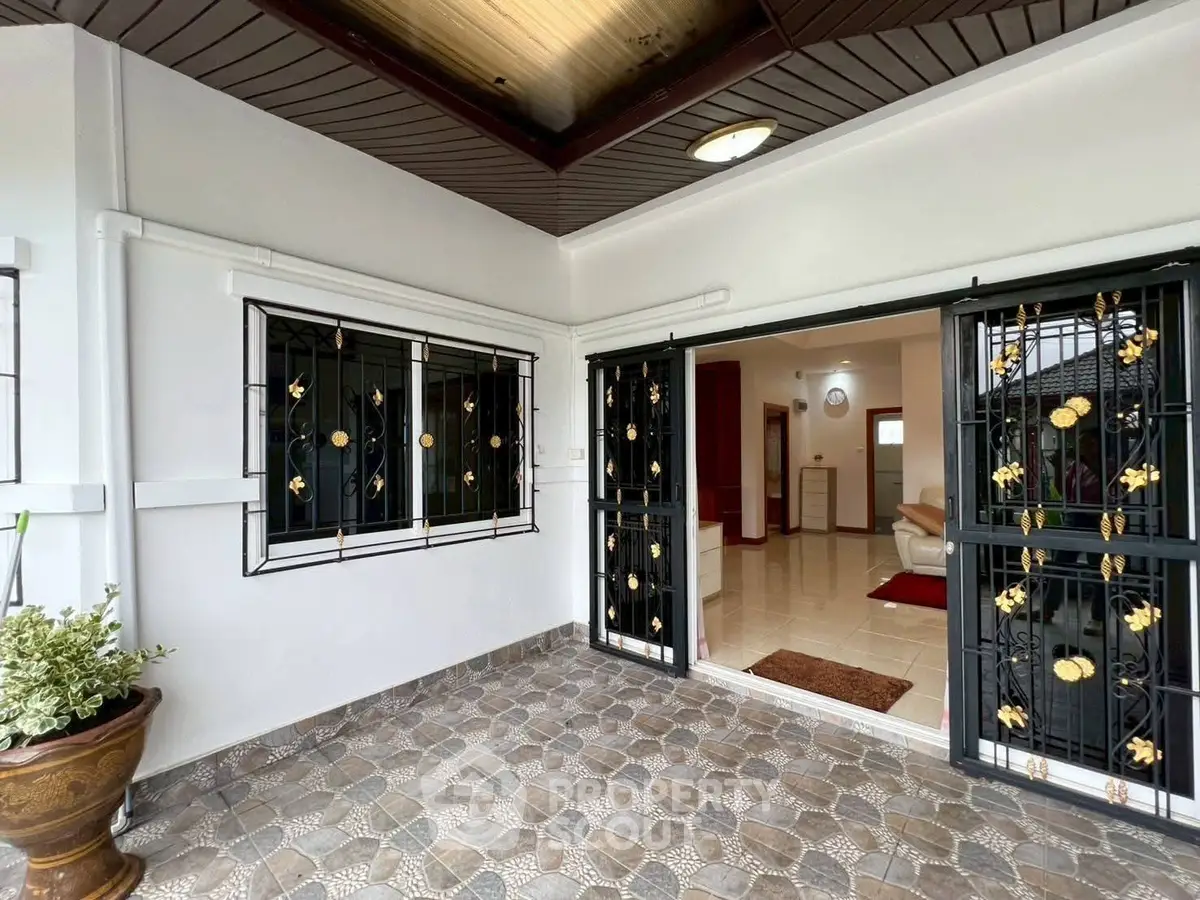 Charming entrance with decorative ironwork and tiled flooring in a cozy home setting.