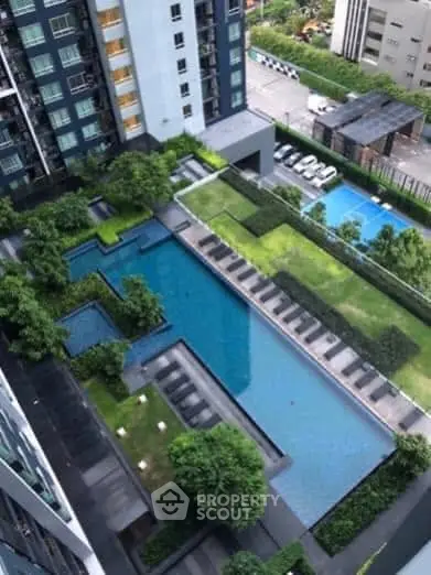 Stunning aerial view of modern condominium with luxurious swimming pool and lush garden.