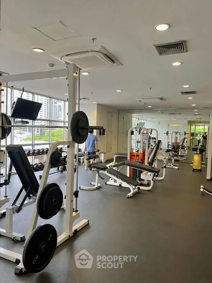 Modern gym with state-of-the-art equipment and city view, perfect for fitness enthusiasts.