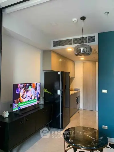 Modern living room with sleek furniture and open kitchen layout in a stylish apartment.