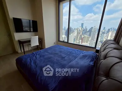 Luxurious bedroom with stunning city skyline view and modern furnishings.