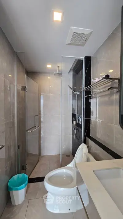 Modern bathroom with glass shower and sleek fixtures in a contemporary apartment.