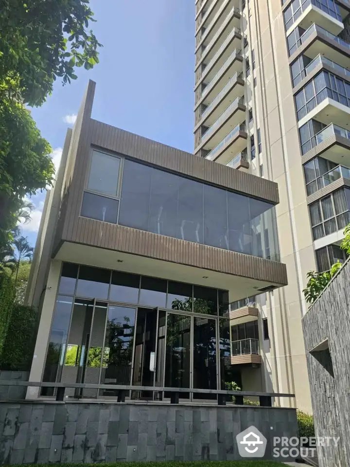 Modern high-rise building with glass facade and lush greenery