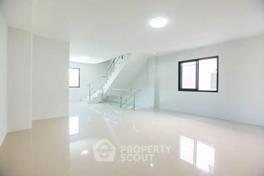 Spacious modern living room with sleek staircase and large windows