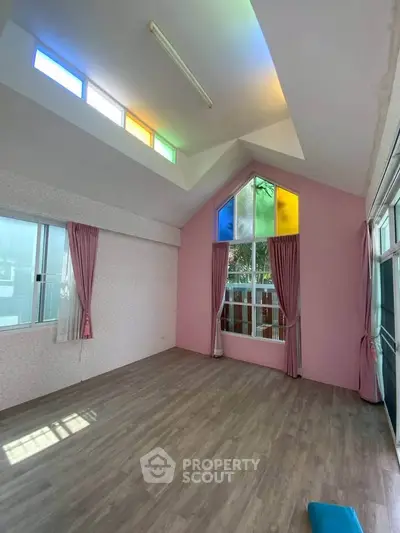 Spacious living room with colorful stained glass windows and high ceiling