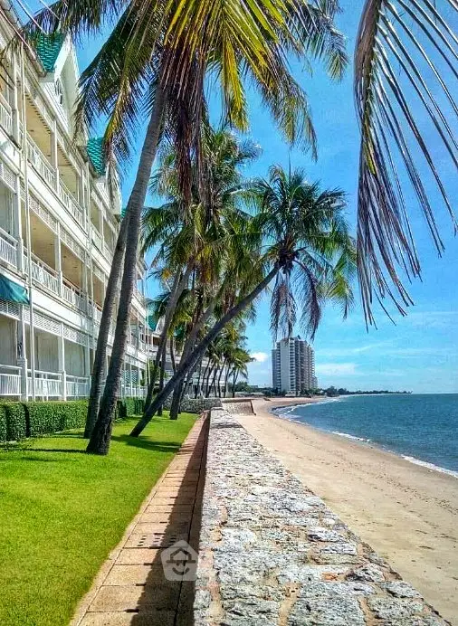 Stunning beachfront property with palm trees and ocean view, perfect for luxury living.