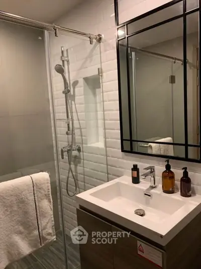 Modern bathroom with sleek shower and stylish vanity in contemporary apartment.