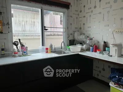 Modern kitchen with sleek countertops and stylish utensil-themed wallpaper