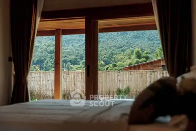 Luxurious bedroom with stunning mountain view through large glass doors, offering a serene and tranquil atmosphere.