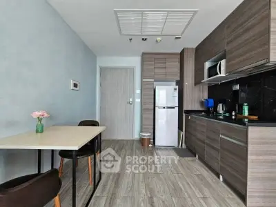 Modern kitchen with sleek cabinetry and dining area in stylish apartment