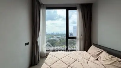 Modern bedroom with large window offering stunning cityscape view