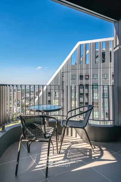 Modern balcony with city view, featuring stylish outdoor furniture and sleek architectural design.