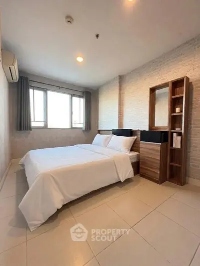 Spacious bedroom with modern decor and large windows in a stylish apartment.