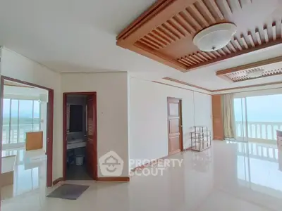 Spacious apartment with ocean view and elegant wooden ceiling details.