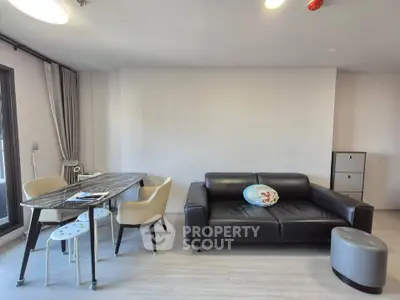 Modern living room with sleek black sofa and stylish dining area