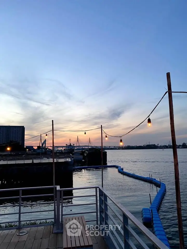 Stunning waterfront view from a deck with ambient lighting at sunset, perfect for relaxation.