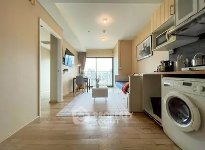Modern open-plan living room with kitchen and balcony view in a stylish apartment.