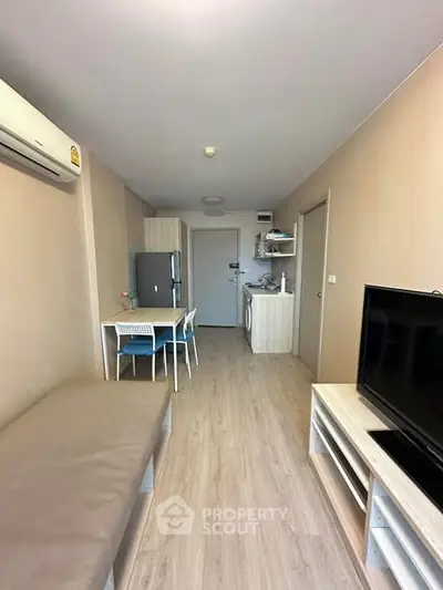 Modern apartment interior with open layout, featuring a cozy living area and compact kitchen.