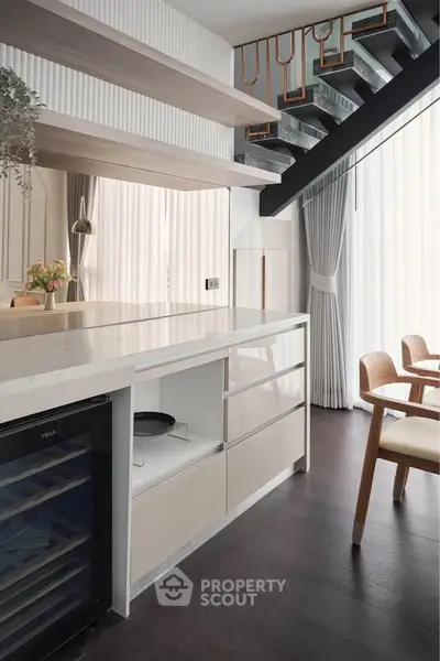 Modern kitchen with sleek design, open layout, and stylish staircase in a contemporary home.