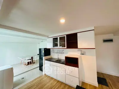 Modern kitchen with sleek cabinetry and dining area in bright open space