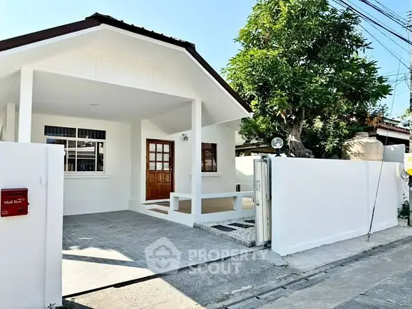 Charming single-story house with a welcoming entrance and spacious driveway.