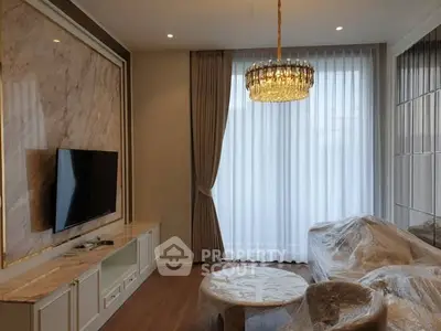 Luxurious living room with elegant chandelier and modern TV setup