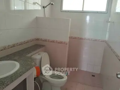 Spacious bathroom with tiled walls and modern fixtures in a real estate property.