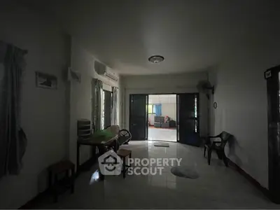 Spacious living room with natural light and tiled flooring