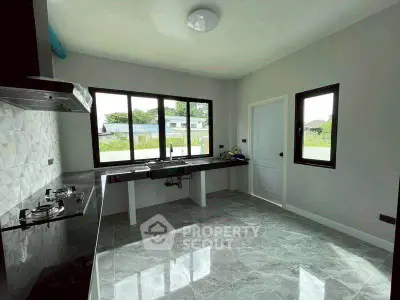 Modern kitchen with sleek countertops and large windows offering natural light and scenic views.