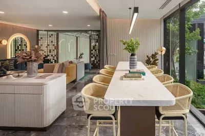 Luxurious open-plan living room with modern kitchen and garden view, featuring elegant decor and ample natural light.