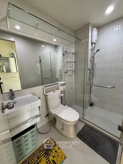 Modern bathroom with glass shower, sleek fixtures, and ample lighting