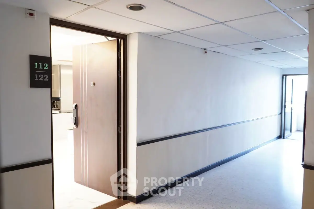 Modern apartment hallway with open door revealing interior