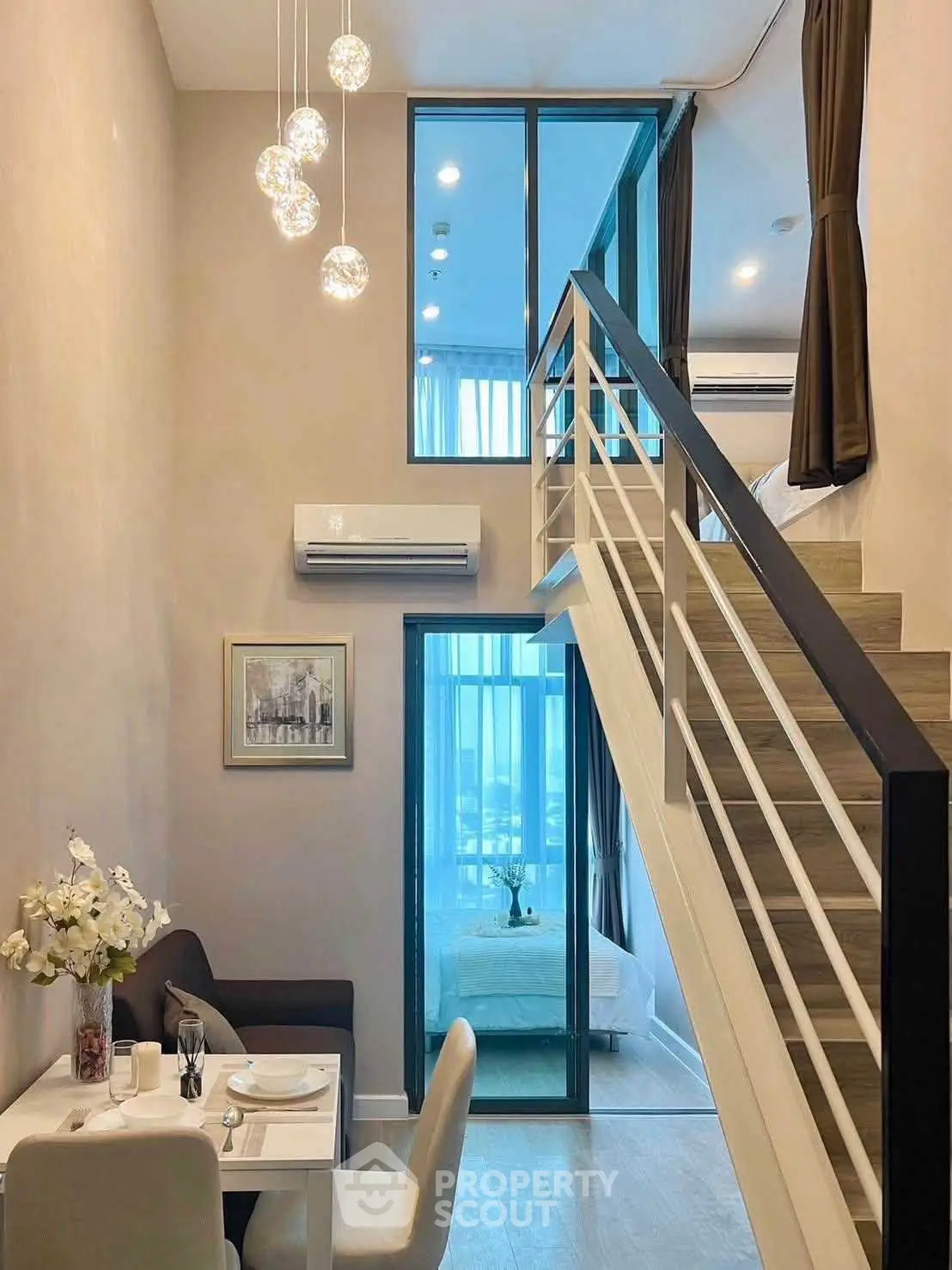 Modern duplex apartment with stylish interior and mezzanine bedroom, featuring elegant lighting and cozy dining area.