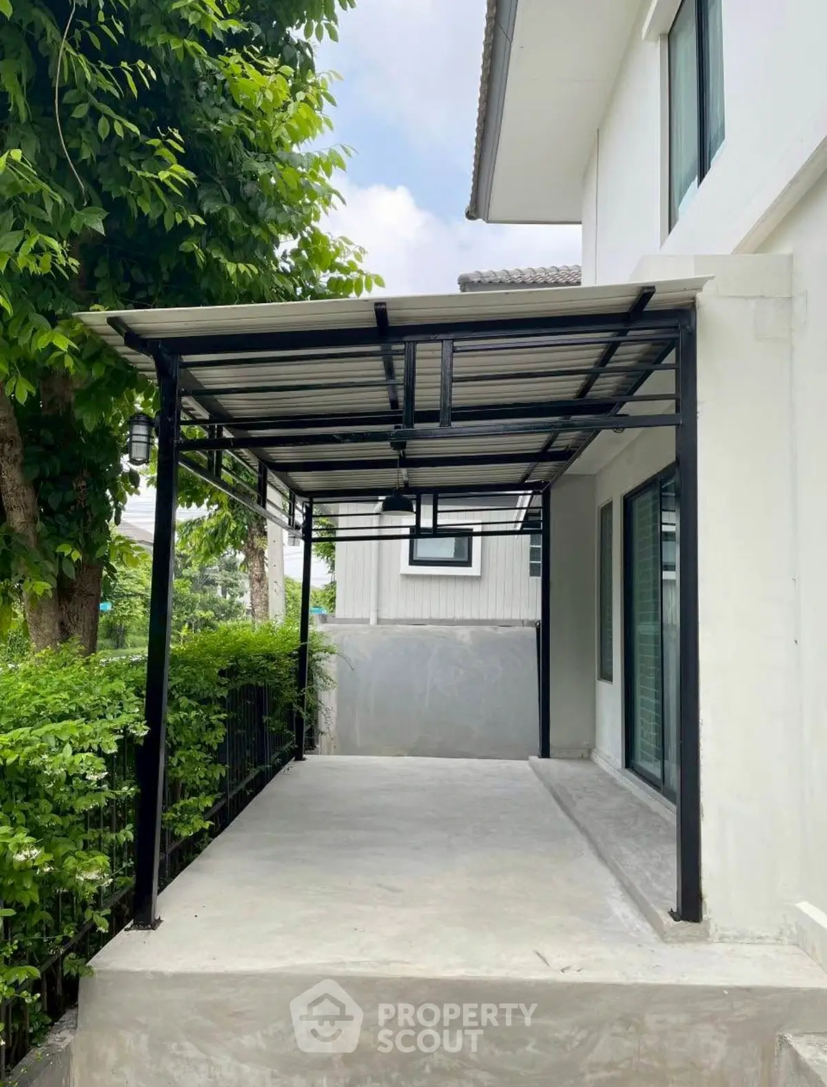 Modern house exterior with covered patio and lush greenery