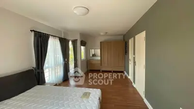 Spacious bedroom with large windows and modern furnishings in a stylish apartment.