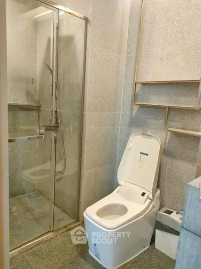 Modern bathroom with sleek shower and high-tech toilet in contemporary apartment.