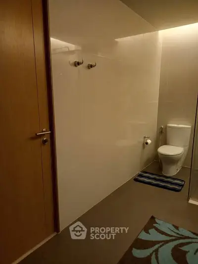 Modern bathroom with sleek design and elegant fixtures, featuring a toilet and stylish flooring.