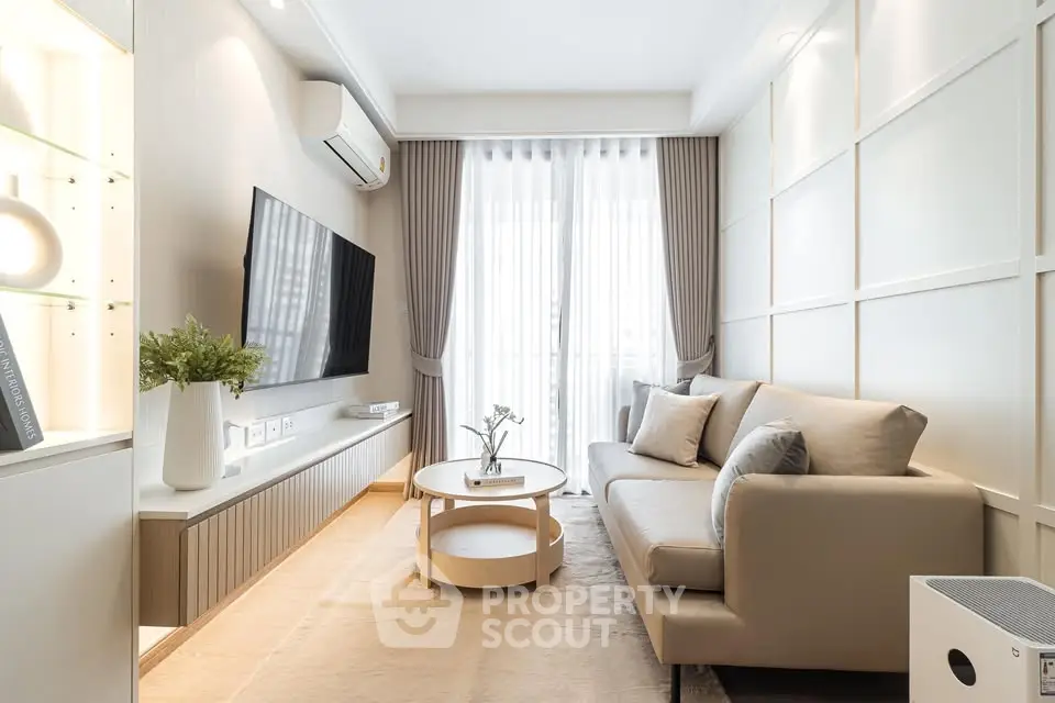 Modern living room with sleek design, featuring a comfortable sofa, wall-mounted TV, and elegant decor.