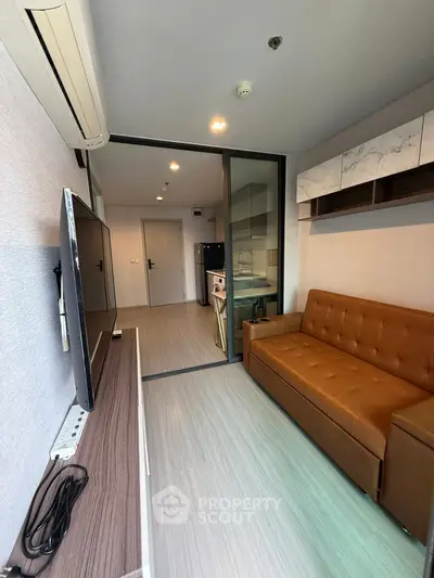Modern living room with brown leather sofa and sleek TV setup