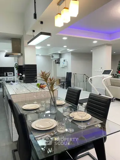 Modern open-plan kitchen and dining area with sleek design and ambient lighting