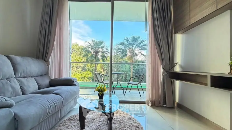 Spacious living room with balcony view of lush greenery and palm trees, featuring cozy seating and modern decor.