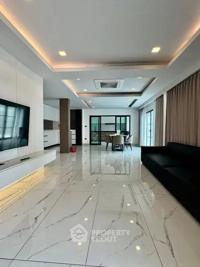 Luxurious modern living room with sleek marble flooring and elegant recessed lighting.