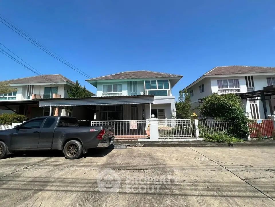 Charming suburban house with driveway and front yard under clear blue sky