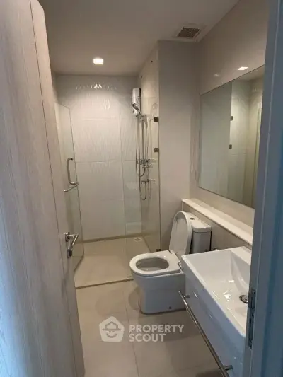 Modern bathroom with glass shower and sleek fixtures in a contemporary apartment.