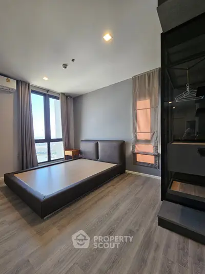 Spacious bedroom with large window and modern minimalist design