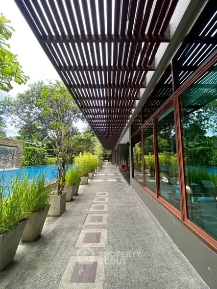 Luxurious poolside walkway with modern design and lush greenery, perfect for relaxation and leisure.