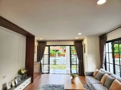 Spacious living room with large windows and garden view, perfect for family gatherings.