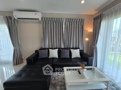 Stylish living room with modern black leather sofa and elegant curtains, perfect for relaxation.