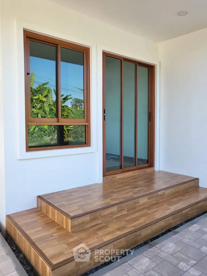Modern entrance with wooden steps and sliding glass door, perfect for contemporary homes.
